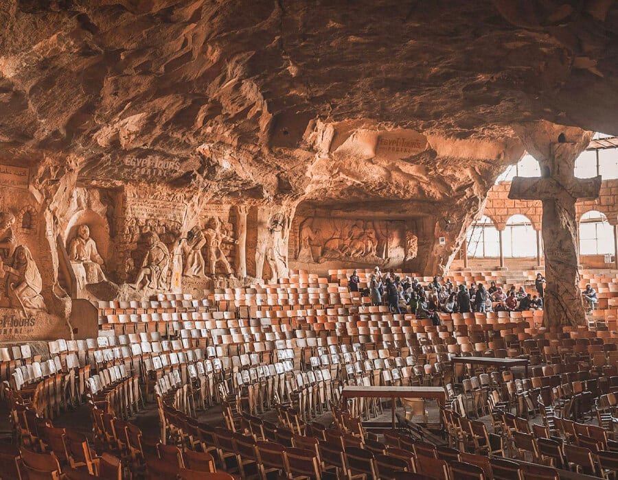 Interior of the Monastery of Anba Samaan cave church, showing tiered seating and rock-carved reliefs