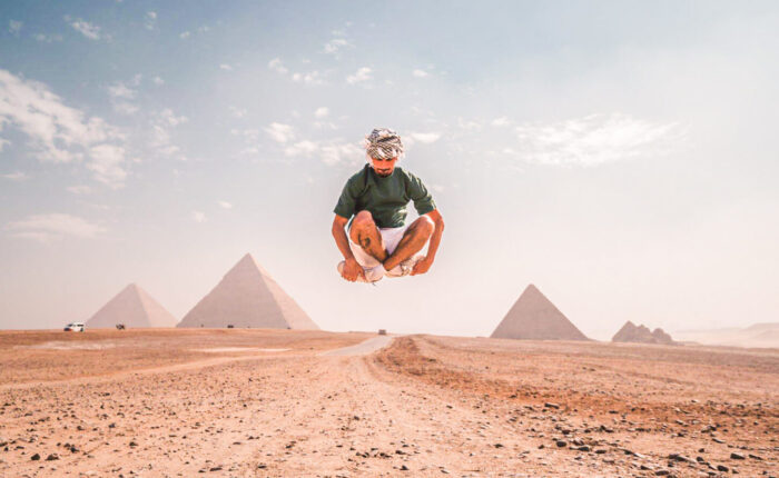 A great photo of a tourist jumping in front of the pyramids of Giza