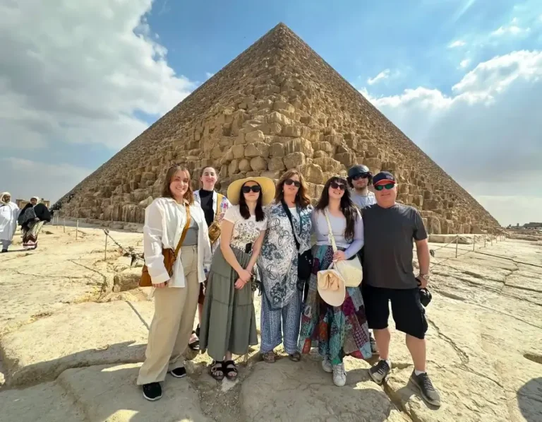 A family standing in front of the Great Pyramid of Giza during a guided tour of the pyramids in Egypt.