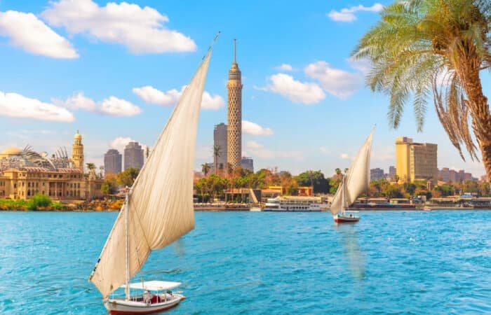 Felucca sailboat on the Nile River with the Cairo Tower and city skyline in the background, Egypt.