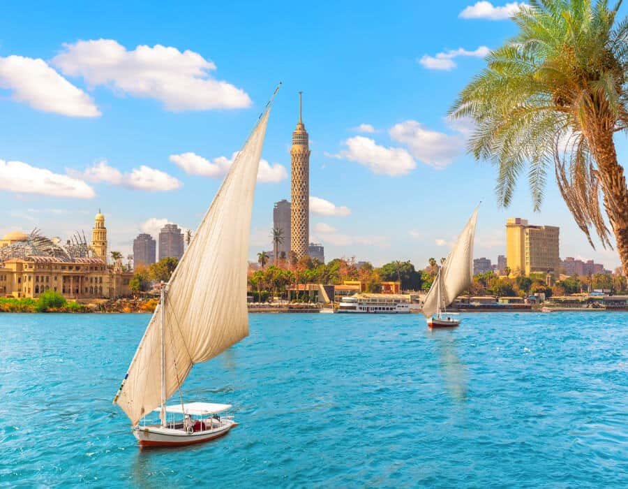 Felucca sailboat on the Nile River with the Cairo Tower and city skyline in the background, Egypt.