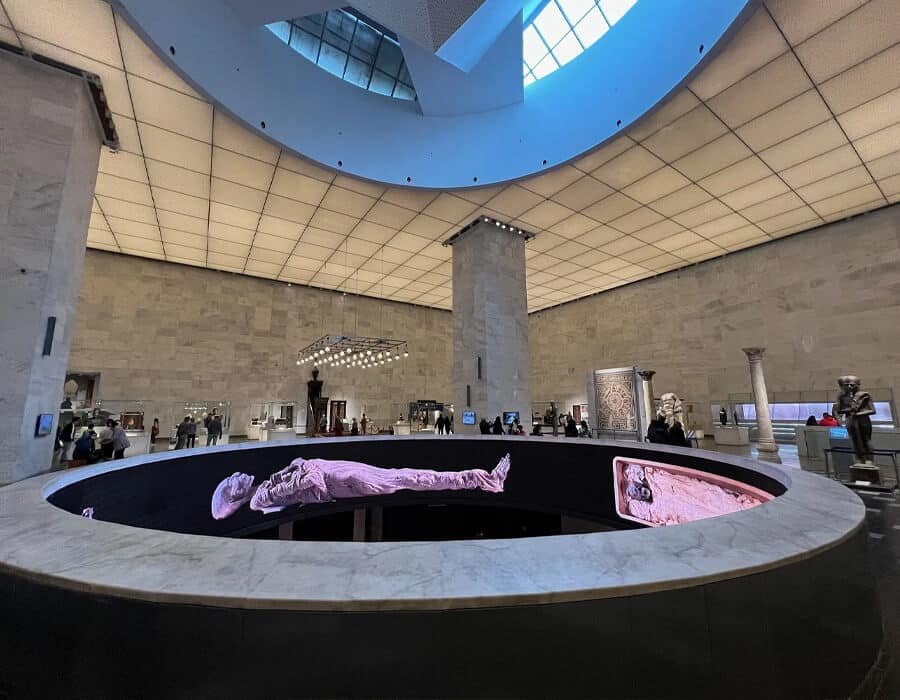 Interior of the Museum of Civilization (NMEC) displaying an illuminated Egyptian mummy in the central hall, one of Cairo's Museums.